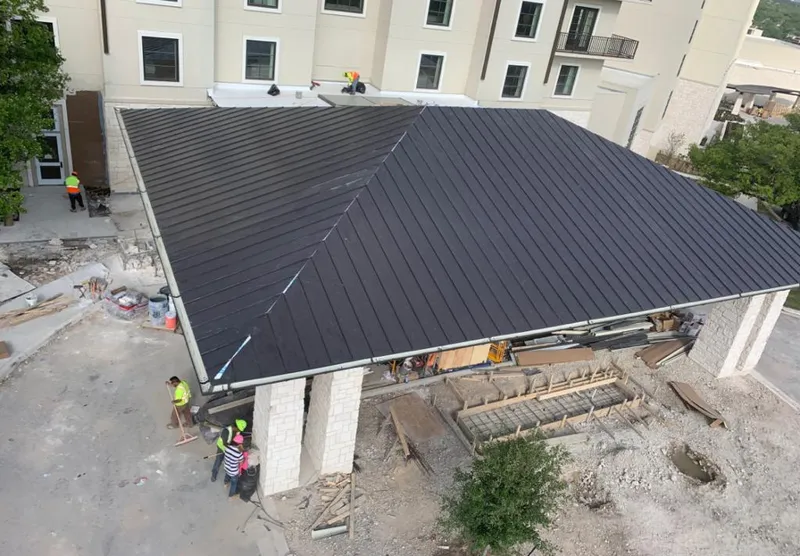 Metal roofing installation team working on a commercial building in New Smyrna Beach